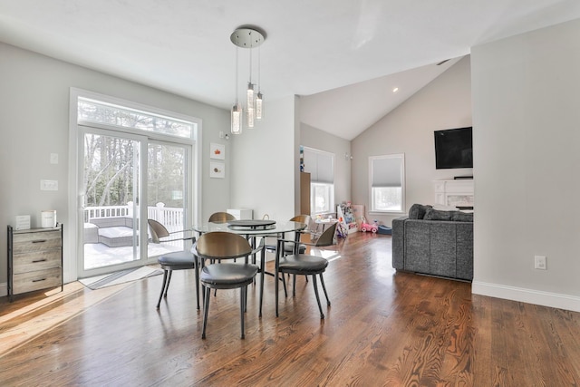 dining area featuring high vaulted ceiling, dark hardwood / wood-style floors, and a healthy amount of sunlight