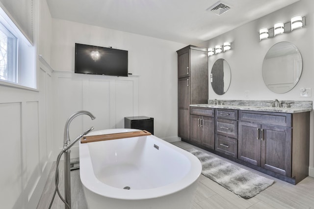 bathroom featuring vanity and a bath