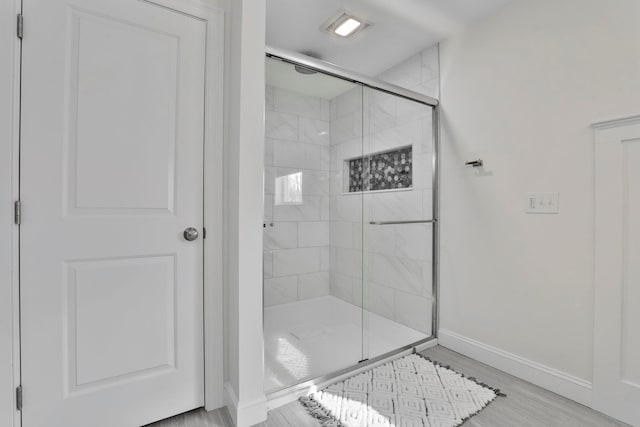 bathroom featuring wood-type flooring and walk in shower