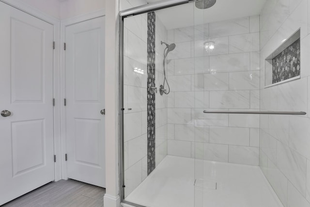 bathroom featuring hardwood / wood-style flooring and a shower with shower door