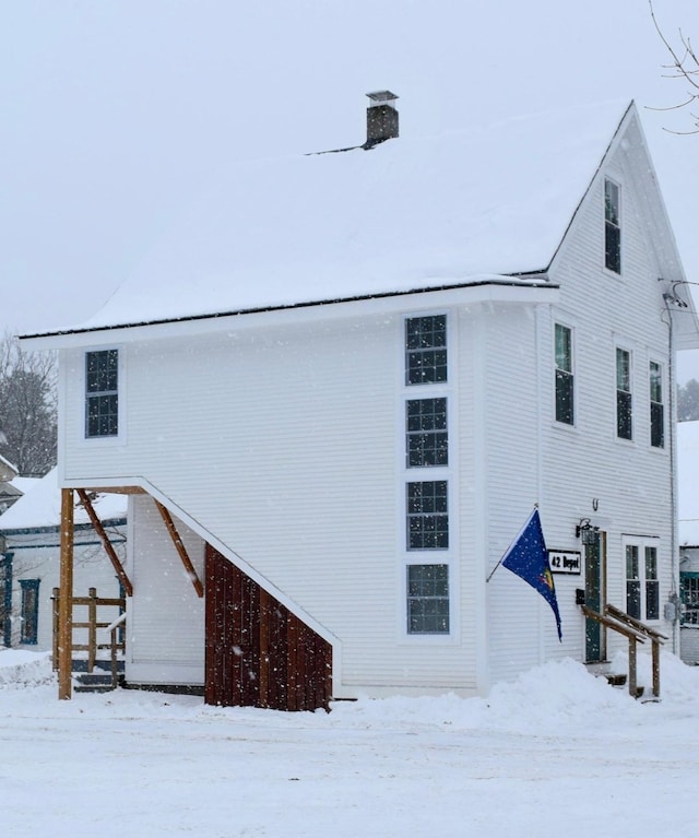 view of snow covered rear of property