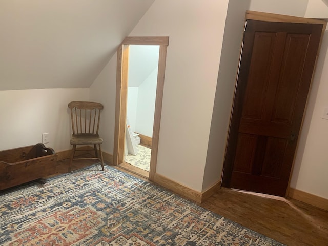 bonus room with hardwood / wood-style flooring and vaulted ceiling