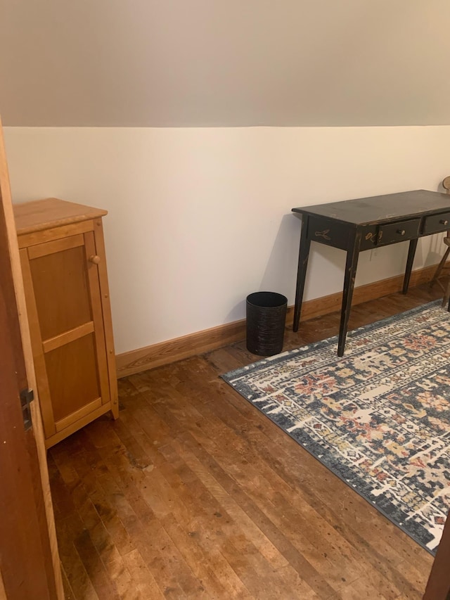 bonus room with dark hardwood / wood-style floors and vaulted ceiling