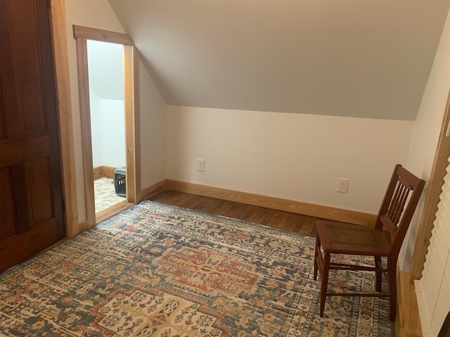 bonus room with hardwood / wood-style flooring and vaulted ceiling