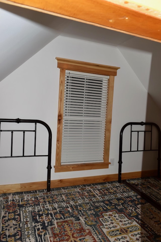 unfurnished bedroom with lofted ceiling and carpet