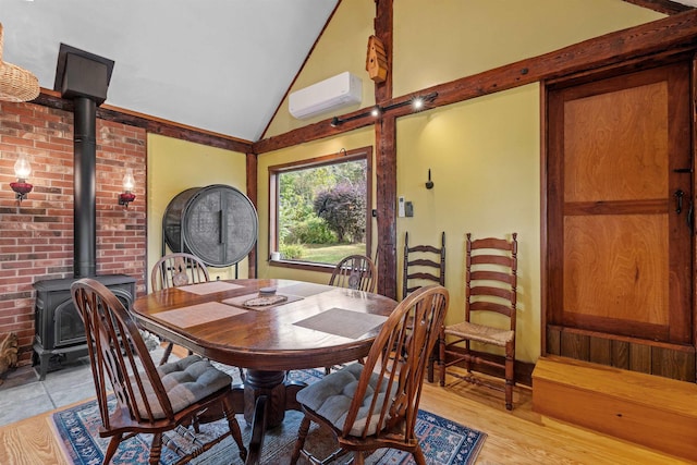 dining space with lofted ceiling, a wall mounted air conditioner, light hardwood / wood-style floors, and a wood stove