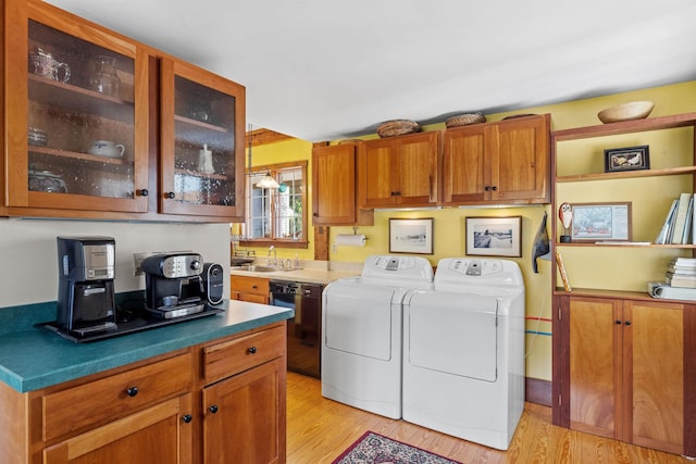 washroom with light hardwood / wood-style floors, sink, and washer and dryer