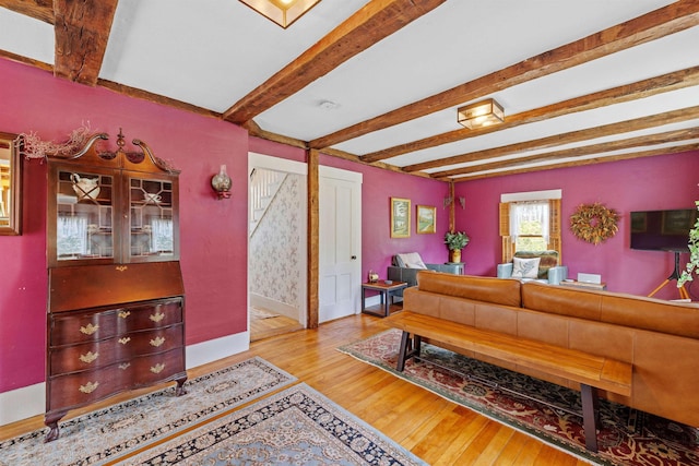 living room featuring light hardwood / wood-style floors and beamed ceiling