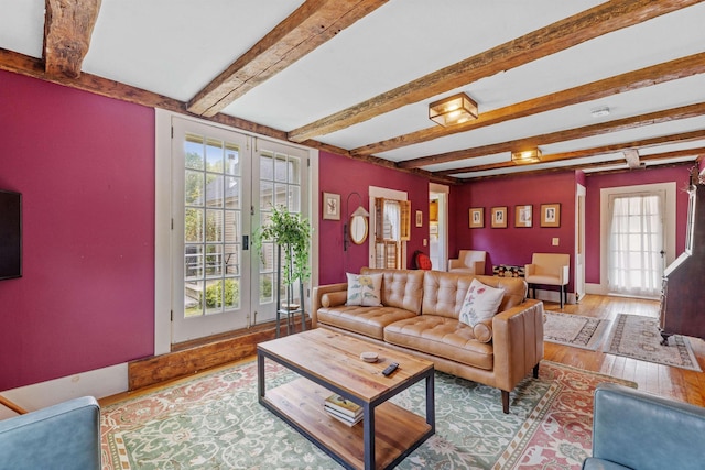 living room featuring hardwood / wood-style floors, beam ceiling, and french doors