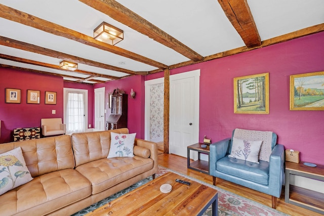 living room featuring beamed ceiling and light wood-type flooring