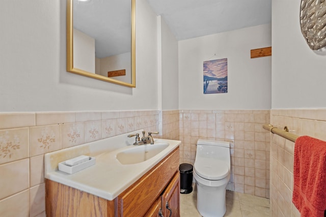 bathroom featuring vanity, toilet, tile patterned flooring, and tile walls