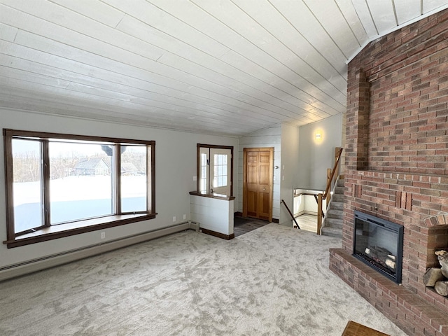 unfurnished living room with vaulted ceiling, carpet, a baseboard heating unit, and a wealth of natural light