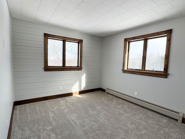 unfurnished room featuring carpet flooring, a baseboard radiator, and plenty of natural light