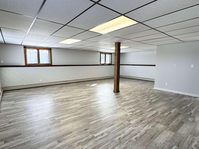 basement with a drop ceiling and hardwood / wood-style floors