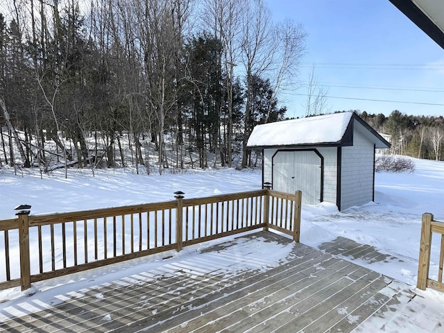 snow covered deck featuring a storage unit