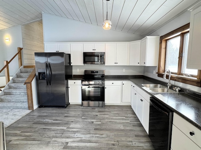 kitchen featuring white cabinetry, appliances with stainless steel finishes, decorative light fixtures, and sink