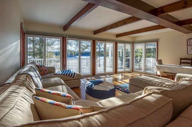 living room with hardwood / wood-style floors, beamed ceiling, and a water view