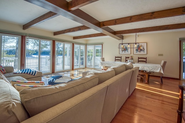 living room with beam ceiling, light hardwood / wood-style flooring, and a textured ceiling