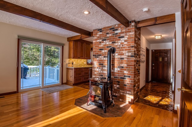 bar featuring beamed ceiling, a textured ceiling, decorative backsplash, and hardwood / wood-style flooring