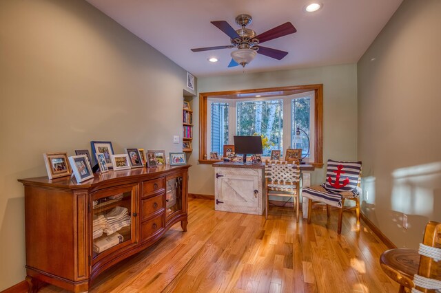 office with light hardwood / wood-style floors and ceiling fan