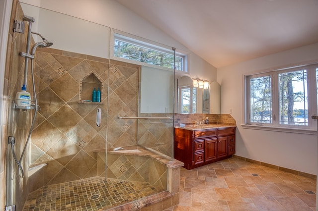 bathroom featuring decorative backsplash, lofted ceiling, a shower with door, and vanity