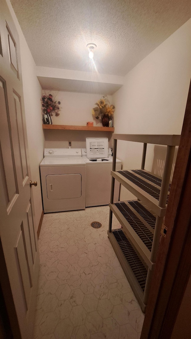 laundry room featuring washing machine and dryer and a textured ceiling