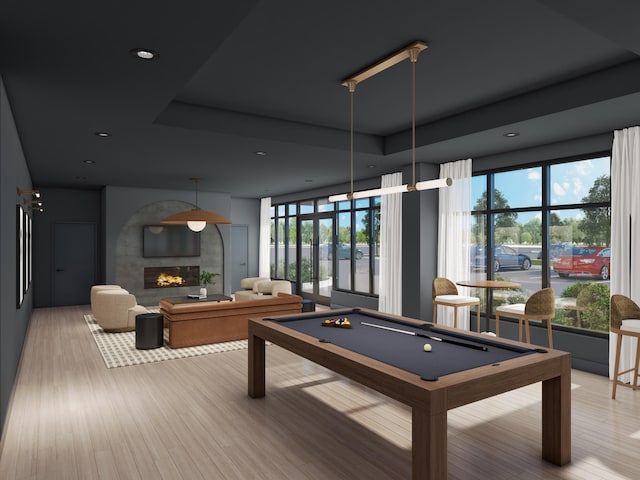 playroom featuring billiards, a raised ceiling, and light hardwood / wood-style floors