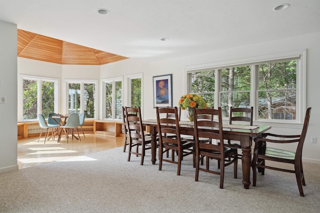 dining area with light carpet, wood ceiling, and plenty of natural light