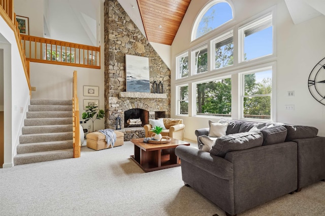 carpeted living room featuring a stone fireplace, high vaulted ceiling, and wood ceiling