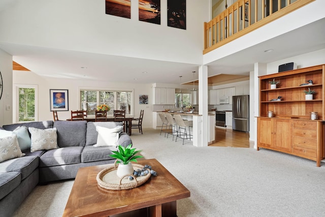 living room with light carpet and a high ceiling