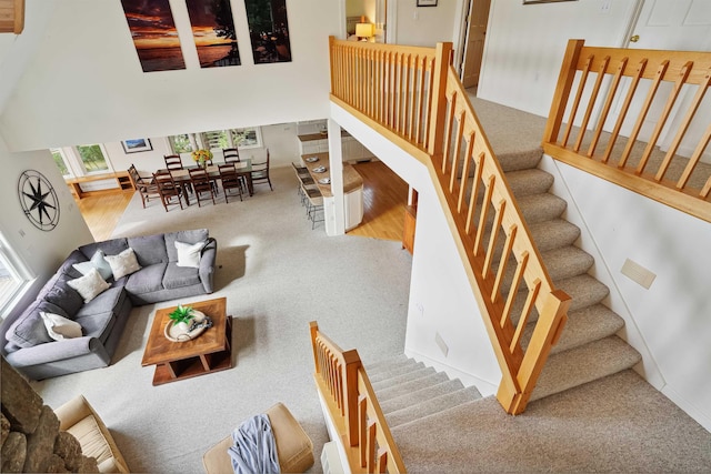 carpeted living room with a towering ceiling