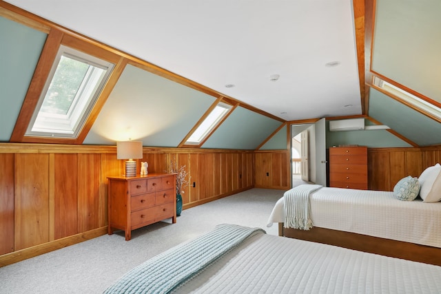 carpeted bedroom featuring vaulted ceiling with skylight and wood walls