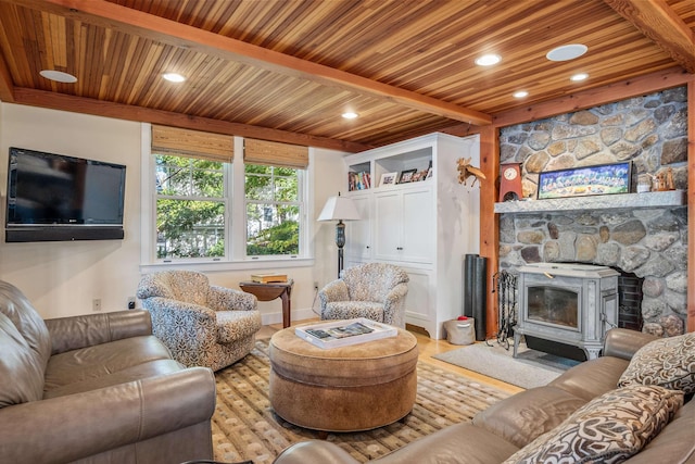 living room featuring wood ceiling, a wood stove, beamed ceiling, and light wood-type flooring