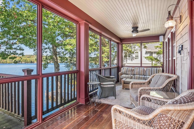 sunroom with a water view and ceiling fan