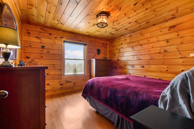 bedroom featuring wood ceiling, wooden walls, and light wood-type flooring