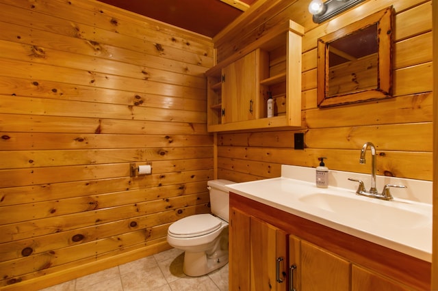 bathroom featuring vanity, tile patterned floors, wooden walls, and toilet