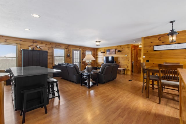 living room with hardwood / wood-style floors and wooden walls