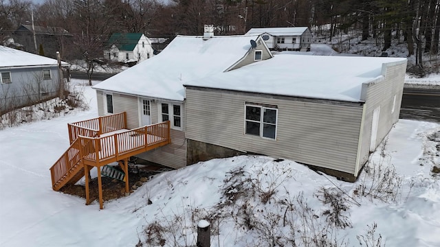 snow covered property featuring a wooden deck