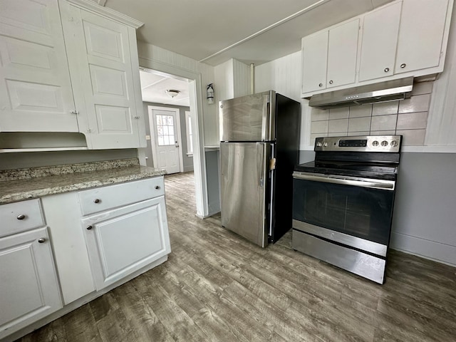 kitchen with stainless steel appliances, decorative backsplash, white cabinets, and light hardwood / wood-style flooring