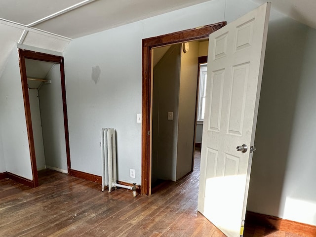 interior space with dark wood-type flooring and radiator heating unit
