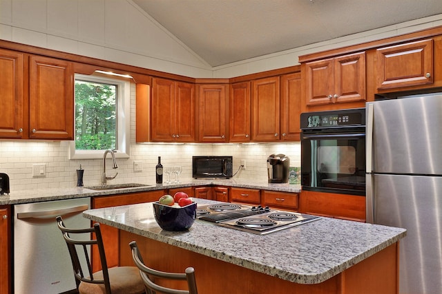 kitchen with lofted ceiling, stainless steel appliances, sink, and a kitchen island