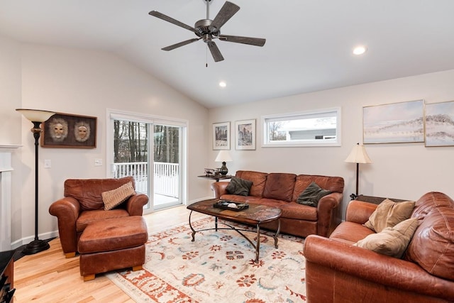 living room featuring ceiling fan, lofted ceiling, and light wood-type flooring