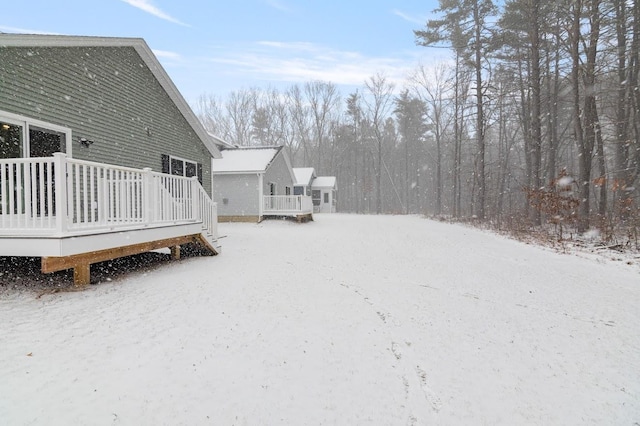 yard layered in snow with a deck