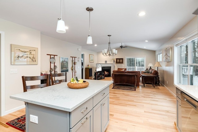 kitchen featuring a center island, vaulted ceiling, gray cabinets, dishwasher, and pendant lighting