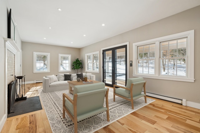 living room featuring french doors, baseboard heating, and light hardwood / wood-style flooring