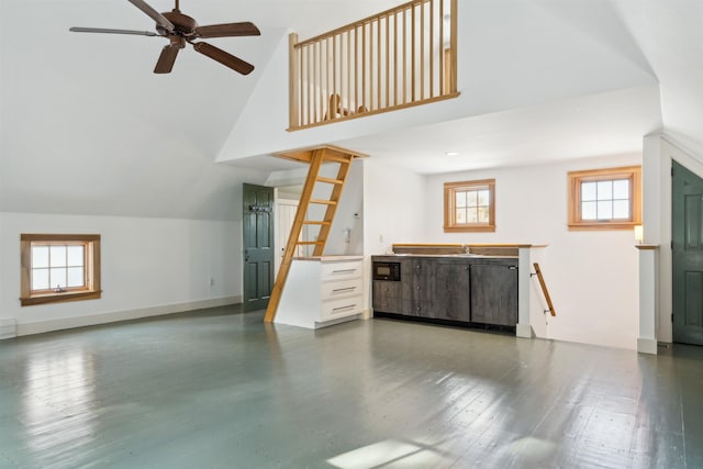 unfurnished living room featuring lofted ceiling, sink, hardwood / wood-style flooring, and ceiling fan