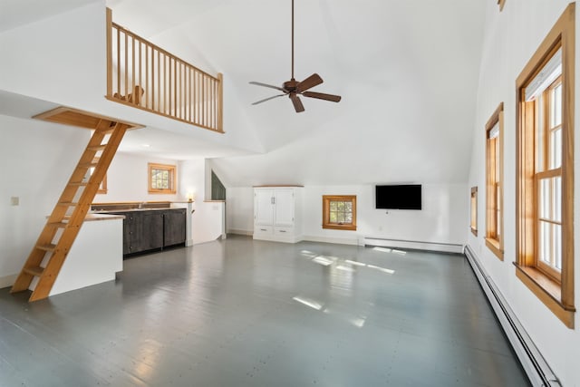 unfurnished living room with a baseboard heating unit, high vaulted ceiling, a healthy amount of sunlight, and ceiling fan