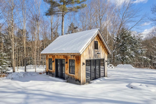 snow covered structure featuring a garage