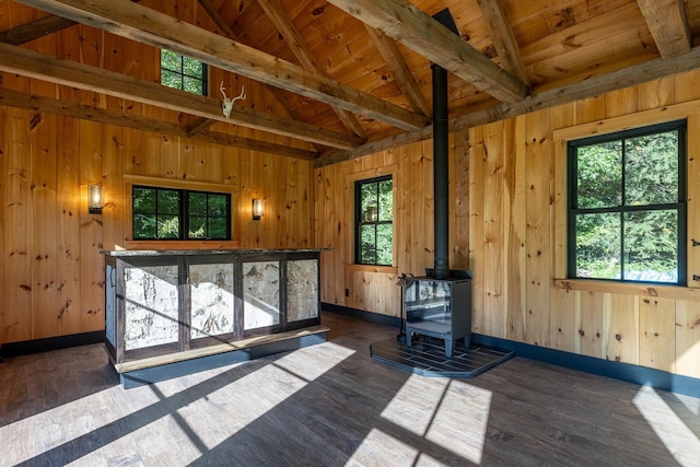 interior space with vaulted ceiling with beams, wood ceiling, dark wood-type flooring, and a wood stove