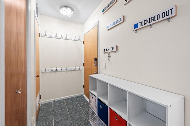 mudroom with dark tile patterned flooring